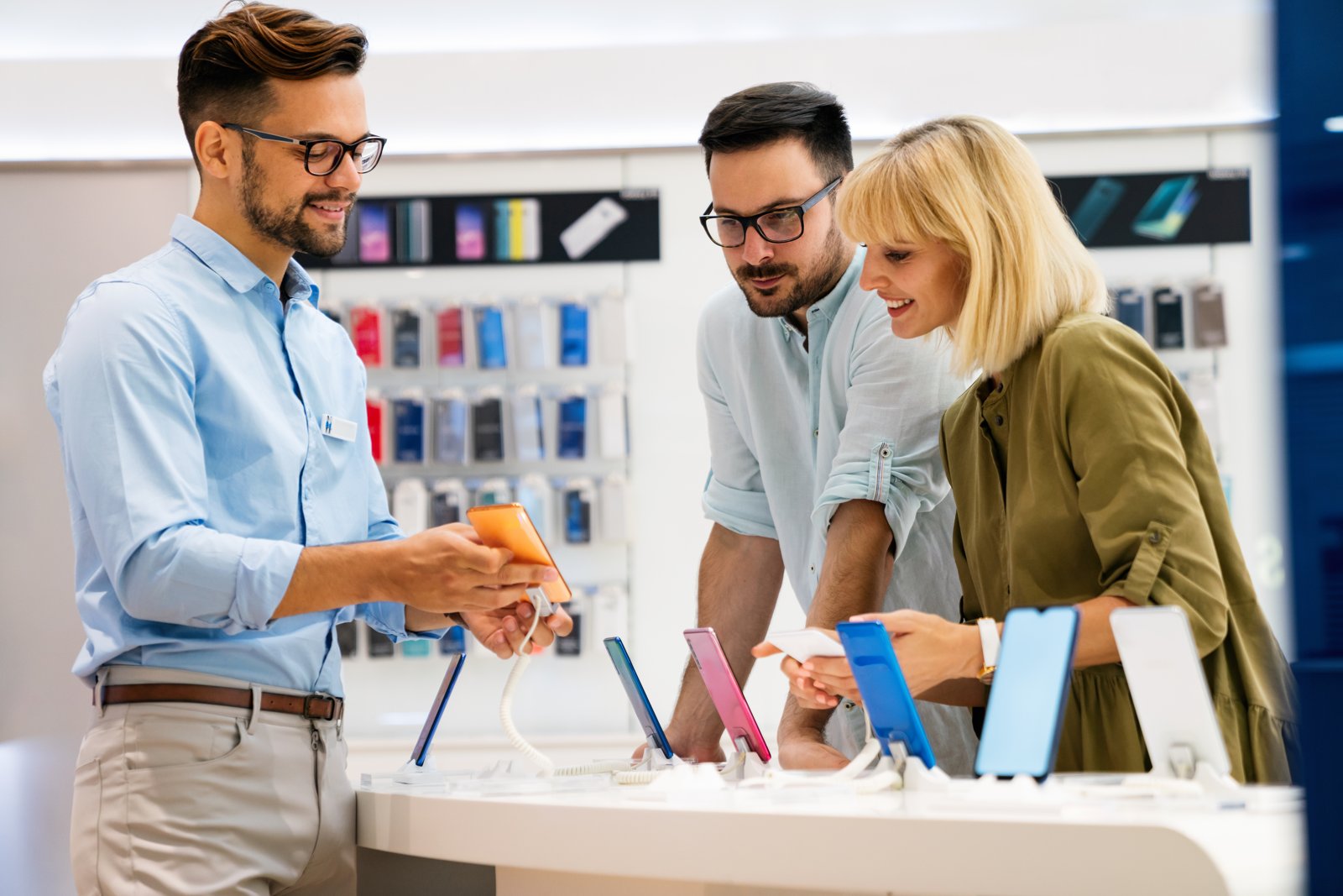 Retail associate helping customers explore mobile devices